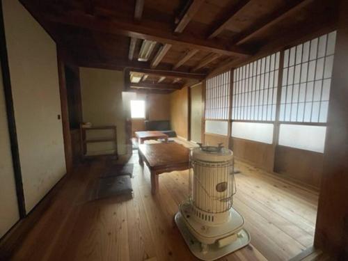 a room with a wooden floor and a room with a heater at NAMIOTO Kumano-Kodo Beachfront Rental House in Kumano