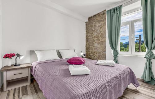 a white bedroom with a purple bed with a window at Cozy Home In Vrgorac With Outdoor Swimming Pool in Vrgorac