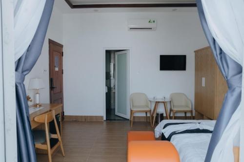 a bedroom with a bed and a table and chairs at Paris Hotel Bình Thuận in Tuy Phong