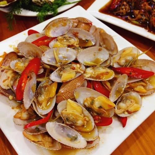 a plate of oysters and vegetables on a table at Paris Hotel Bình Thuận in Tuy Phong
