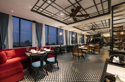 a restaurant with a red couch and tables and chairs at Shining Central Hotel & Spa in Hanoi