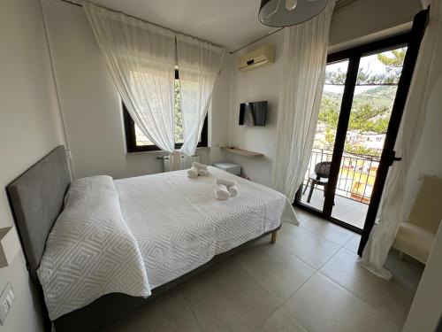 um quarto com uma cama com lençóis brancos e uma janela em MIRA taormina rooms em Taormina