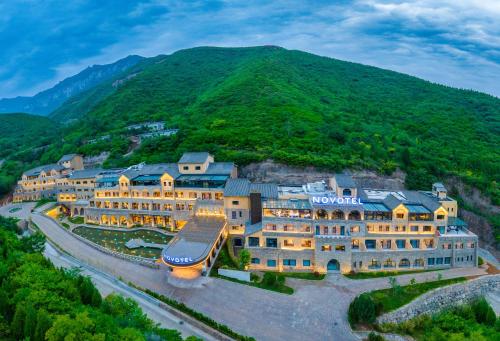 eine Luftansicht eines Hotels mit einem Berg im Hintergrund in der Unterkunft Novotel Linfen Mount Yun in Xiangning