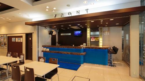 a restaurant with a blue bar with tables and chairs at Toyoko Inn Nagoya Nishiki in Nagoya