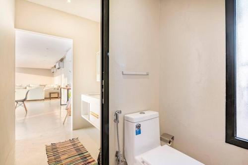 a white bathroom with a toilet in a room at Desert farm gateway W/ pool & horse in Hunaywah