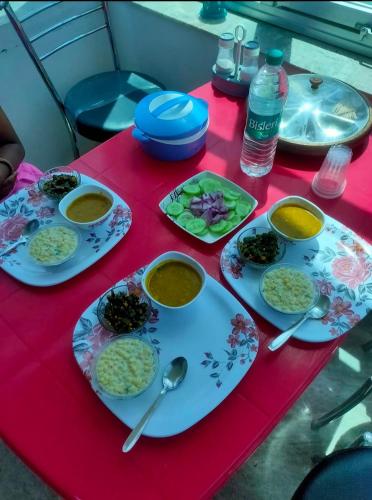 a table with plates of food on a red table at Fort View Guest House - Sariska in Alwar