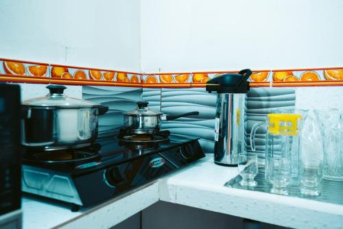 a kitchen counter with a stove with a pot on it at POSADA MIS 3 BENDICIONES in Paracas