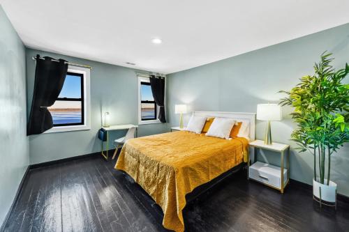 Fox LakeにあるRandolph Hotelのベッドルーム1室(黄色のベッドカバー付)、窓2つが備わります。