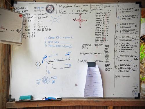 a whiteboard with drawings and a vase on it at Daroyen Village in Kri