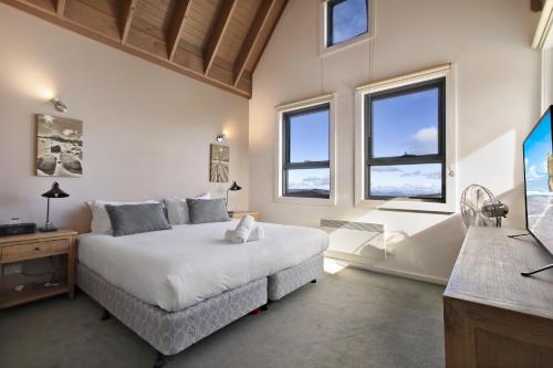a bedroom with a bed and two windows at White Crystal 206 in Mount Hotham
