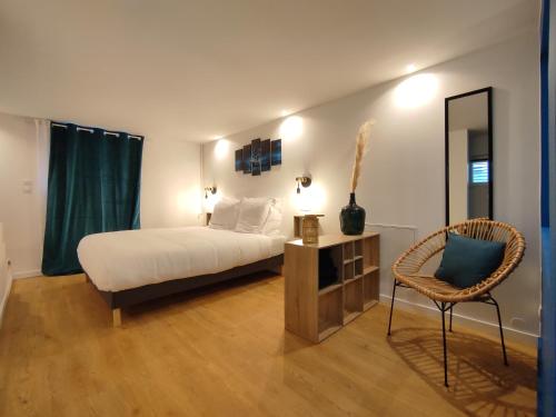 - une chambre avec un lit, une chaise et un miroir dans l'établissement Maison de ville, SPA Balnéo, 2 suites parentales, à Vichy