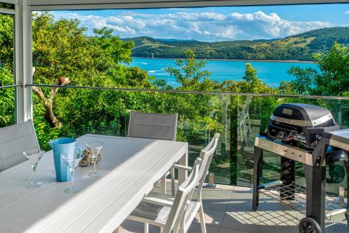a view from the balcony of a house with a grill at Oasis Apartments on Hamilton Island by HIHA in Hamilton Island