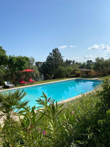 uma grande piscina azul num quintal em Chambres d'hôtes de charme La Joséline em Flayosc
