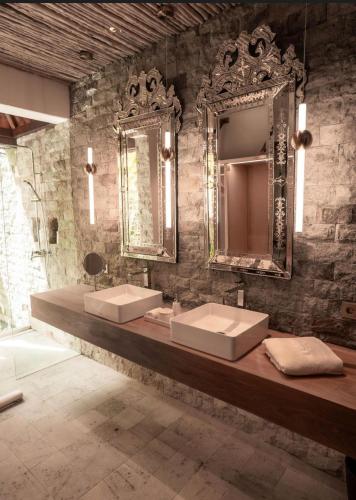 a bathroom with two sinks and two mirrors at La Reserve 1785 Canggu Beach - Adults Only in Canggu
