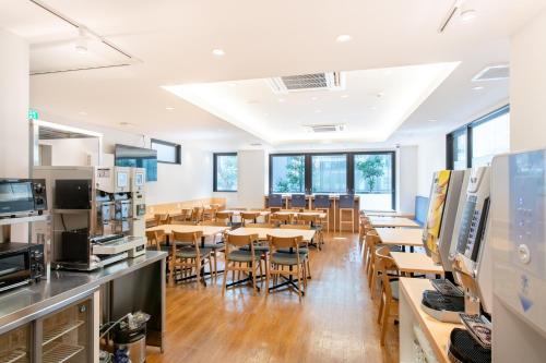 a classroom with tables and chairs in a cafeteria at Hotel Sanrriott Osaka Hommachi in Osaka