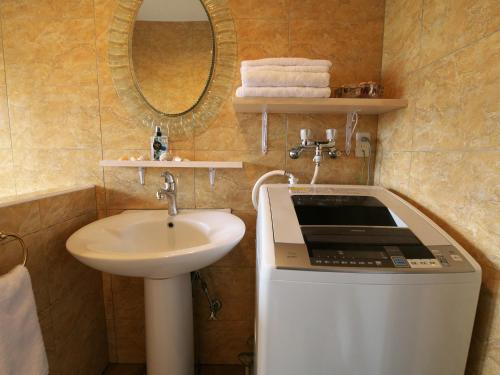 a bathroom with a sink and a laptop on a counter at Ocean Villa Tin Gala in Onna
