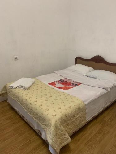 a bed with a blanket on it in a bedroom at Leila Apartment in Tbilisi City