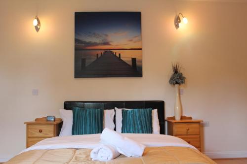 a bedroom with a bed and a picture on the wall at Remarc Guest House in Takeley