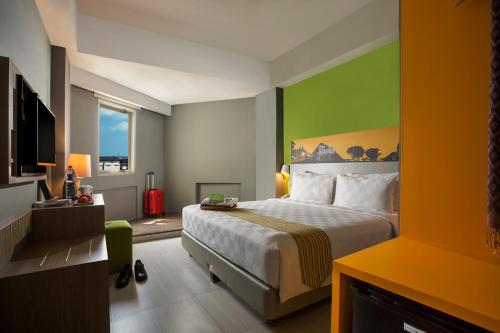 um quarto de hotel com uma cama e uma parede verde em KHAS Malioboro Hotel em Yogyakarta