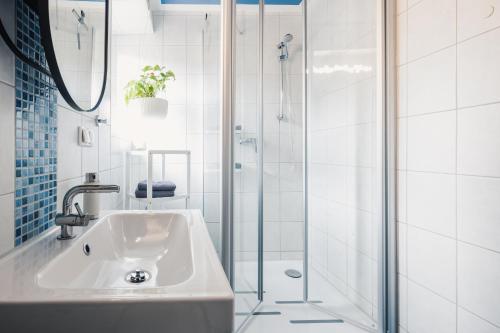 a white bathroom with a shower and a sink at Ferienwohnung "UtTied" - komfortabel und modern! in Klausdorf Mecklenburg Vorpommern