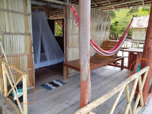 a hammock on a porch of a house at Daroyen Village in Kri