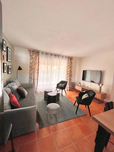 un salon avec un canapé et une télévision à écran plat dans l'établissement Maison de vacances dans Résidence avec Piscine, à Arles