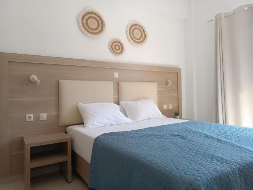 a bedroom with a large bed with a blue blanket at KELLY APARTMENTS in Ýpsos