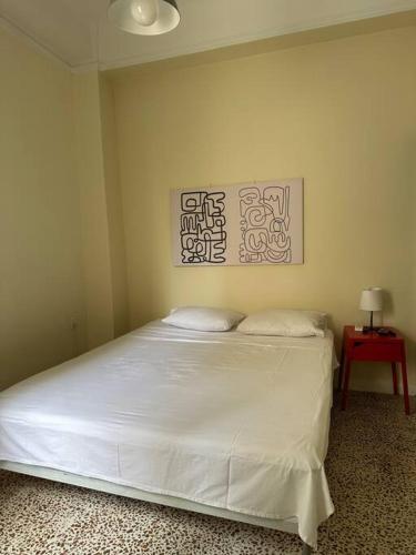1 dormitorio con cama blanca y mesa roja en Heart of Athens thiseio (2), en Atenas