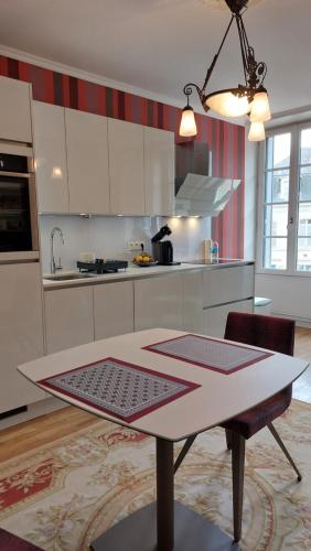 a kitchen with a table in the middle of it at SUPREMATISME Appartement de Prestige in Vierzon