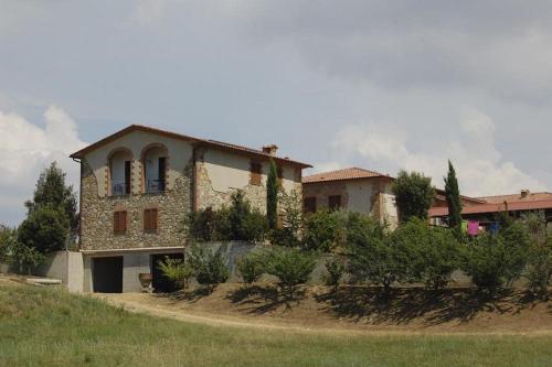 a house on a hill next to a field at Apartment Il Casino numero 5 in Laiatico