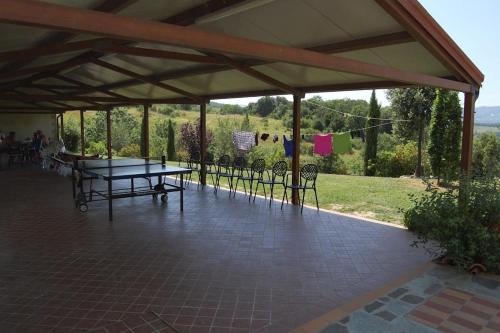 a pavilion with a table and chairs on a patio at Apartment Il Casino numero 5 in Laiatico