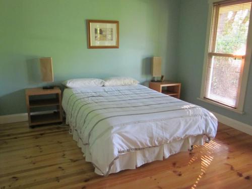 a bedroom with a large bed with white sheets at 14 McLardy Courtes in Cowes