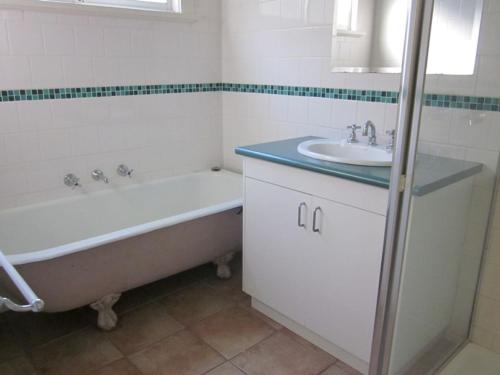 La salle de bains est pourvue d'une baignoire et d'un lavabo. dans l'établissement 14 McLardy Courtes, à Cowes