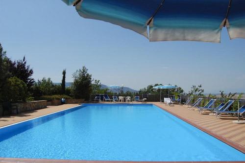 a large swimming pool with blue water and chairs at Apartment Il Casino numero 5 in Laiatico