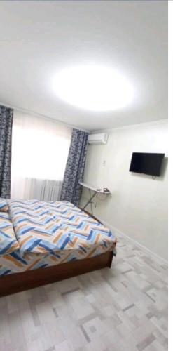 1 dormitorio con cama y ventana grande en Циолковского с кодовым замком, en Uralsk