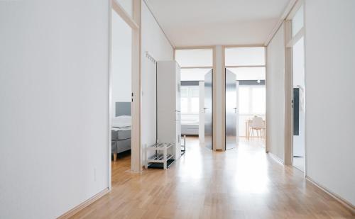 uma sala de estar com paredes brancas e piso em madeira em F&E Apartment - groß, freundlich hell em Fellbach