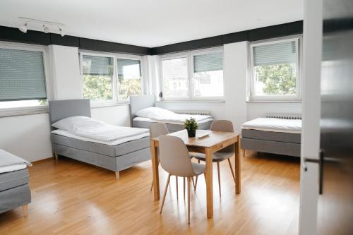 um quarto com duas camas, uma mesa e cadeiras em F&E Apartment - groß, freundlich hell em Fellbach
