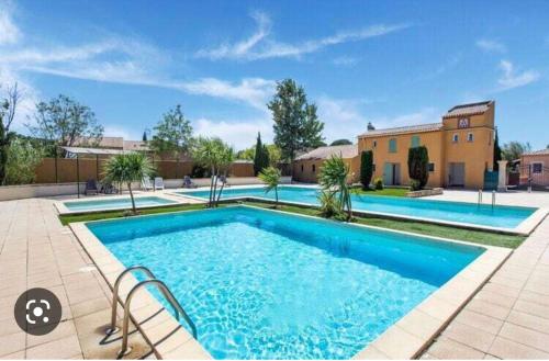 une grande piscine devant une maison dans l'établissement Maison de vacances dans Résidence avec Piscine, à Arles