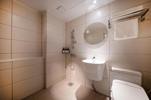 uma casa de banho com um WC, um lavatório e um espelho. em HOTEL SOHA em Gumi