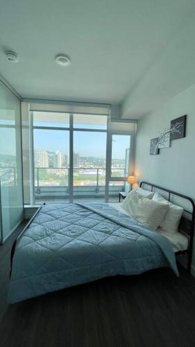 a bedroom with a large bed with a large window at Brand New Starling Luxury Condo with Mountain Views in Burnaby