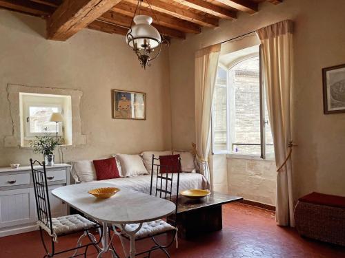 a living room with a table and a couch at Appartement aux Arènes in Arles