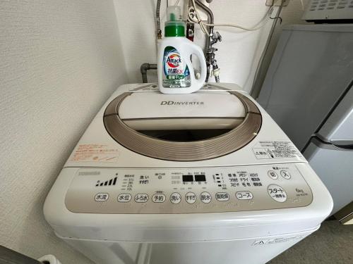 a washing machine with a bottle on top of it at Hokusei Bldg 41 ほくせいビル 41号室 in Sapporo