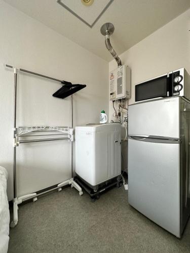 a kitchen with a refrigerator and a microwave at Hokusei Bldg 41 ほくせいビル 41号室 in Sapporo