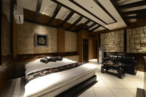 um quarto com uma cama grande e um sofá em HOTEL Sweets em Mobara