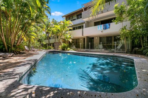 a swimming pool in front of a building at Little Cove Treetops Little Cove Magic in Noosa Heads