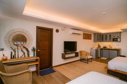 Habitación de hotel con cama y TV en Banig Beach Resort El Nido, en El Nido