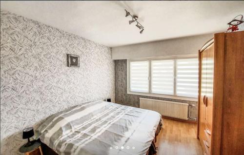 um quarto com uma cama e uma janela em zouzoubelle em Coudekerque-Branche