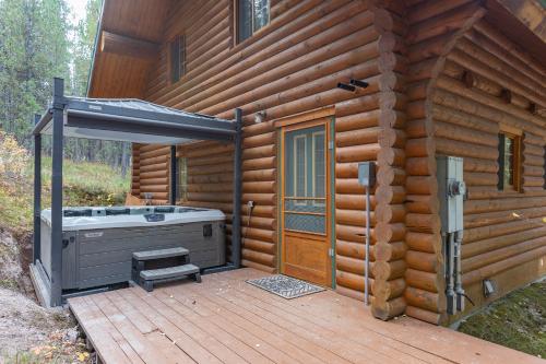 アイランド・パークにあるHenrys Cast by KABINO Hot Tub Large Driveway PS4 Dog Friendly Fire Pit Fireplaceの木製デッキにホットタブが付いたキャビンです。