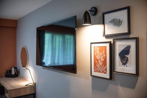 une chambre avec un miroir et des photos sur un mur dans l'établissement Wilmslow Lodge, à Wilmslow