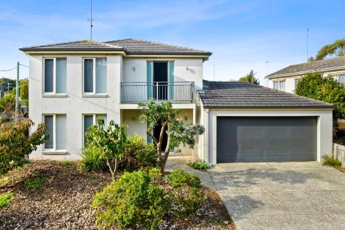 a white house with a garage in front of it at Retreat on Gairloch I Geelong River Hideaway in Geelong